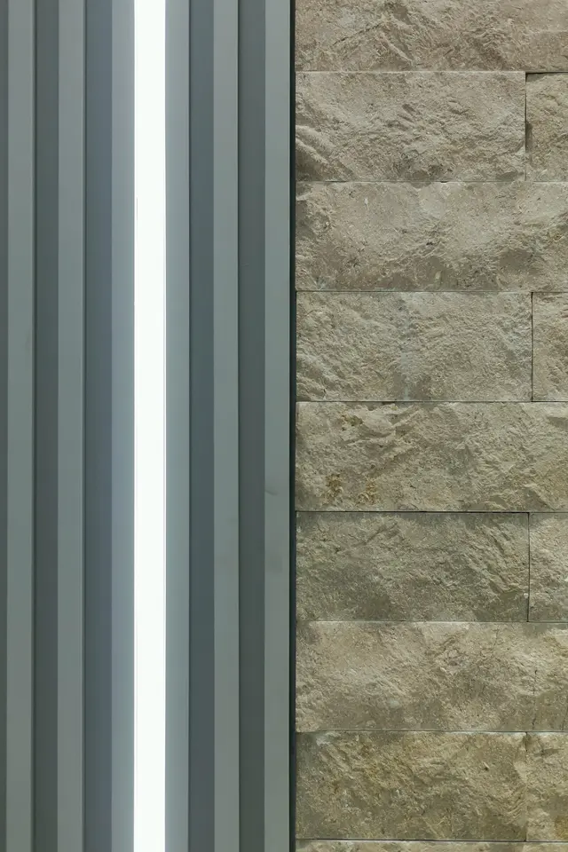Detalhe de ripado, perfil de LED e pedra